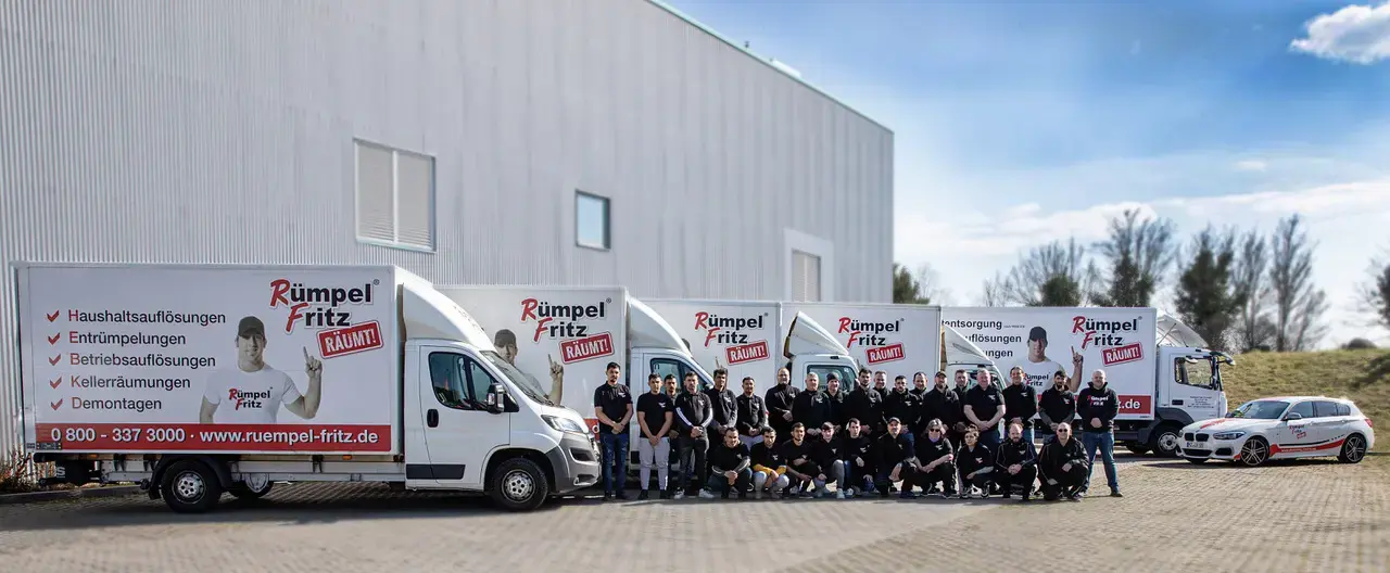 Das Team von Rümpel Fritz vor dem gebrandeten Fuhrpark